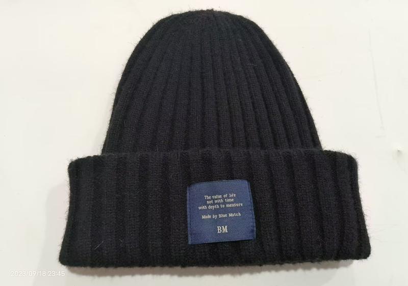 Czarna gruba prążkowana czapka zimowa beanie z podwijanym mankietem i niebieską etykietą – hurtownia B2B