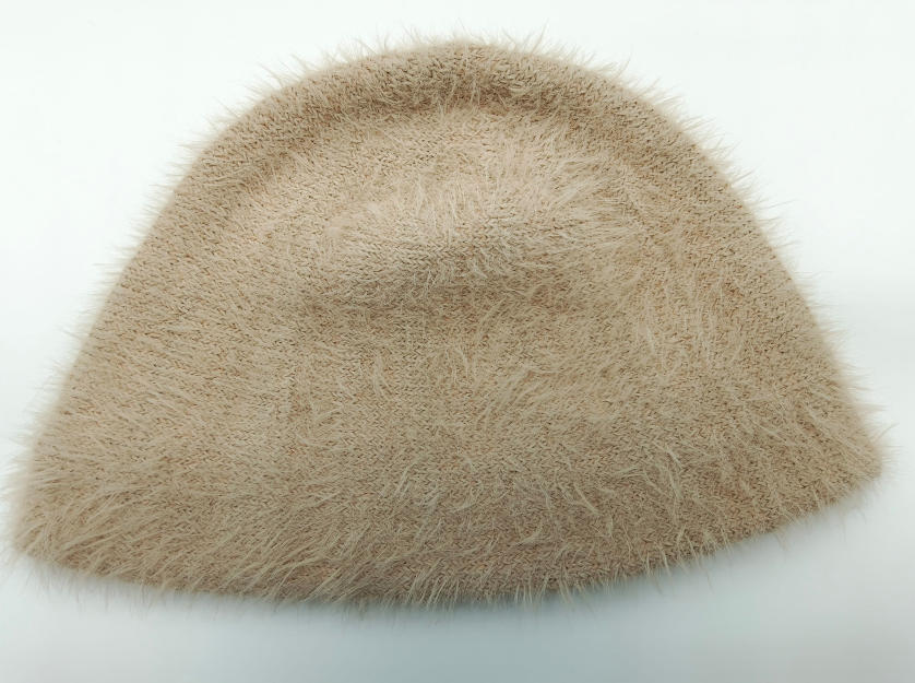 Beżowy bucket hat z puszystej dzianiny z teksturą rzęs, miękkie futrzane wykończenie, zdjęcie z góry.