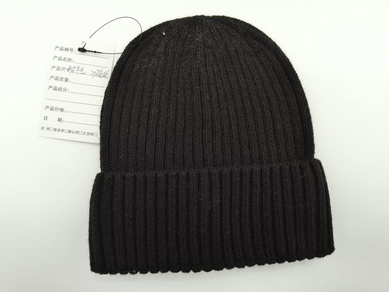 Czarna prążkowana czapka beanie z podwiniętym mankietem, wykonana z dzianiny.