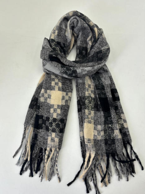 Złożony tkany szal w czarno-szaro-kremową kratę patchwork z frędzlami na końcach, białe tło.