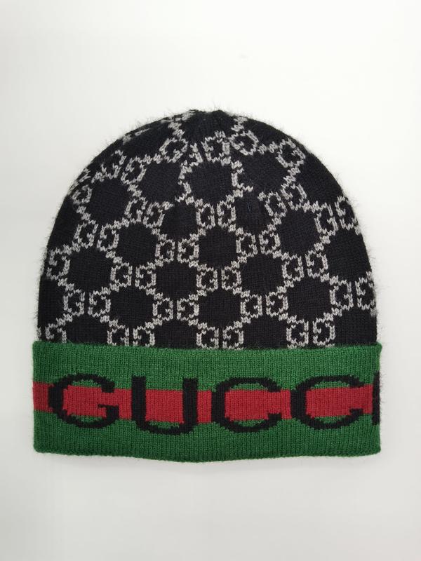 Czarno-szara czapka beanie z monogramem i zielono-czerwonym pasiastym mankietem, białe tło.