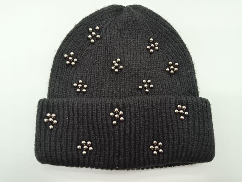 Czarna prążkowana czapka zimowa typu beanie z ozdobnymi kwiatowymi klastrami z srebrnych metalicznych koralików na mankiecie.