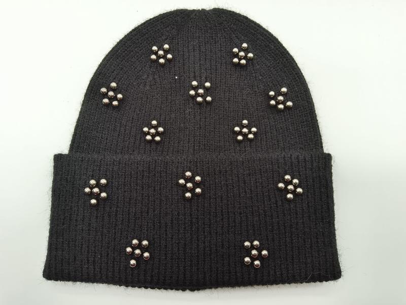 Czarna prążkowana czapka beanie ze srebrnymi ćwiekami w kształcie kwiatów na mankiecie i czubku.