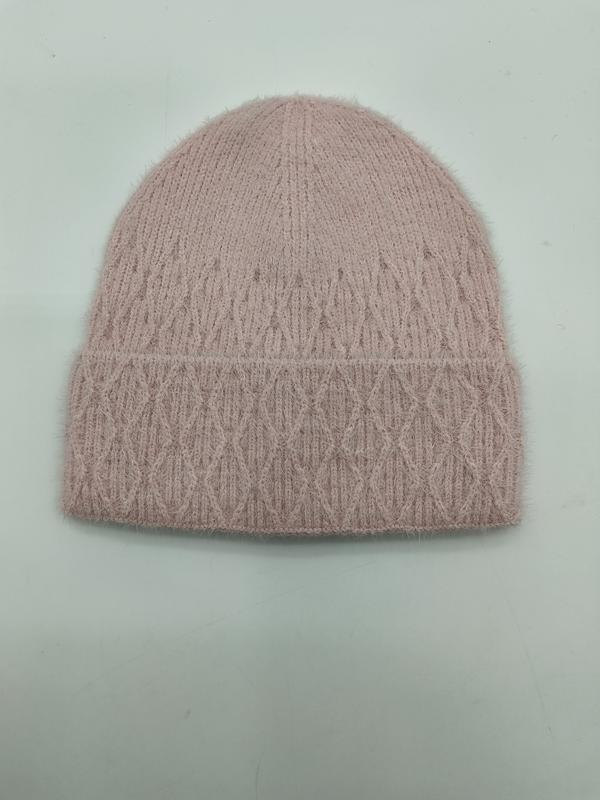 Różowa puszysta czapka beanie z warkoczowym splotem, wzorem w romby i podwiniętym mankietem na jasnym tle.