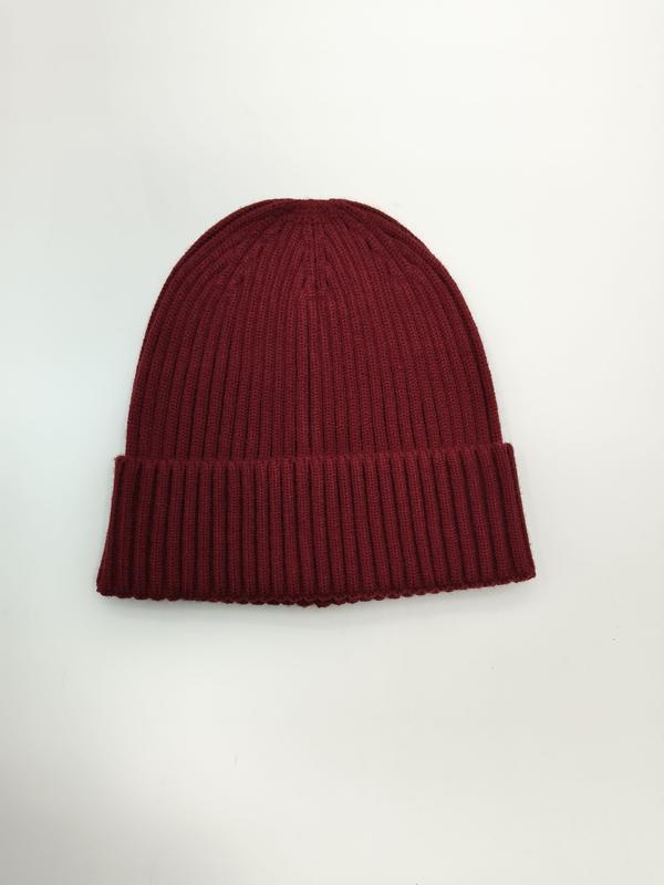 Bordowa czapka beanie z prążkowanej dzianiny z podwójnie podwiniętym mankietem, widok z góry na białym tle.