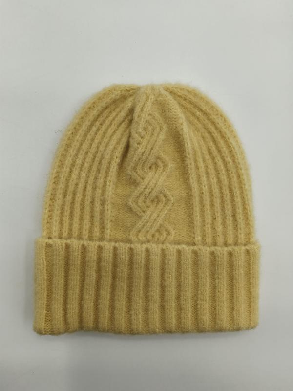 Żółta czapka beanie z wełny z prążkowanym splotem i wzorem warkoczowym, złożonym mankietem, na białym tle.