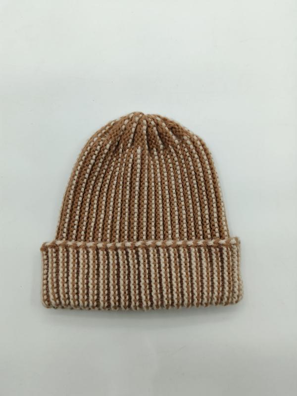Kremowo-beżowa dwukolorowa prążkowana czapka beanie z podwiniętym mankietem na białym tle.