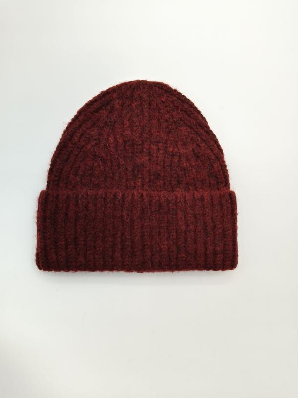 Ciemnoburgundowa czapka beanie z grubym prążkowanym splotem i podwiniętym mankietem, na białym tle.