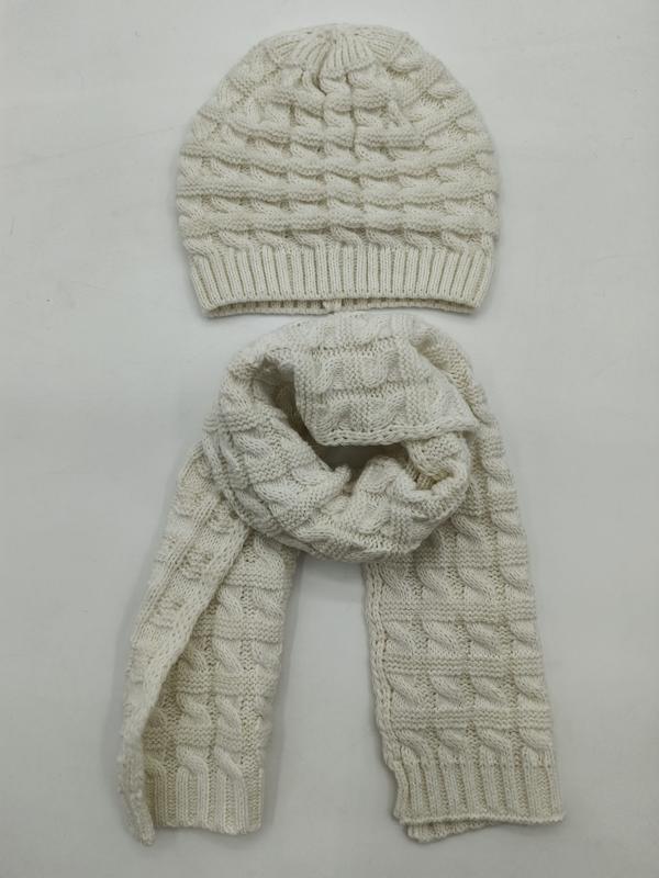 Kremowa czapka beanie i szalik w warkoczowy splot – zimowy zestaw na białym tle.