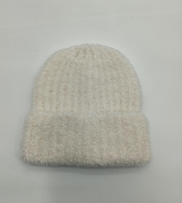 Kremowa, puszysta czapka beanie z prążkowanej dzianiny, miękka i puszysta, luźna czapka zimowa na białym tle.