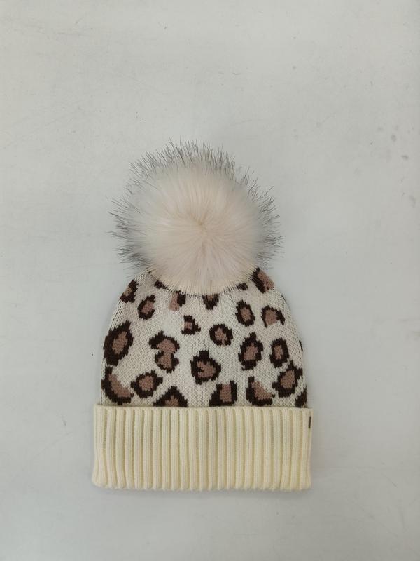 Kremowa czapka beanie z brązowym wzorem w cętki i puszystym pomponem z sztucznego futra, żebrowany mankiet.