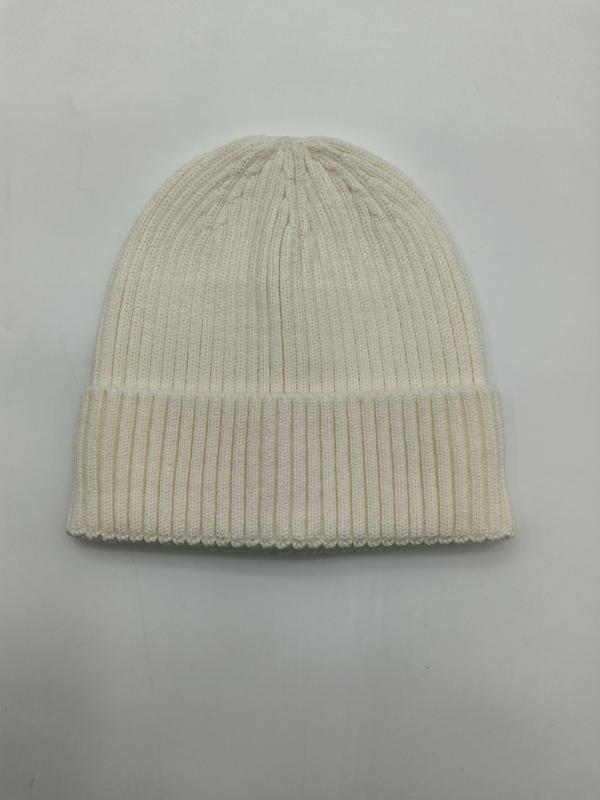 Kremowa czapka beanie z prążkowanej dzianiny z wywiniętym mankietem, widok z góry na białym tle.