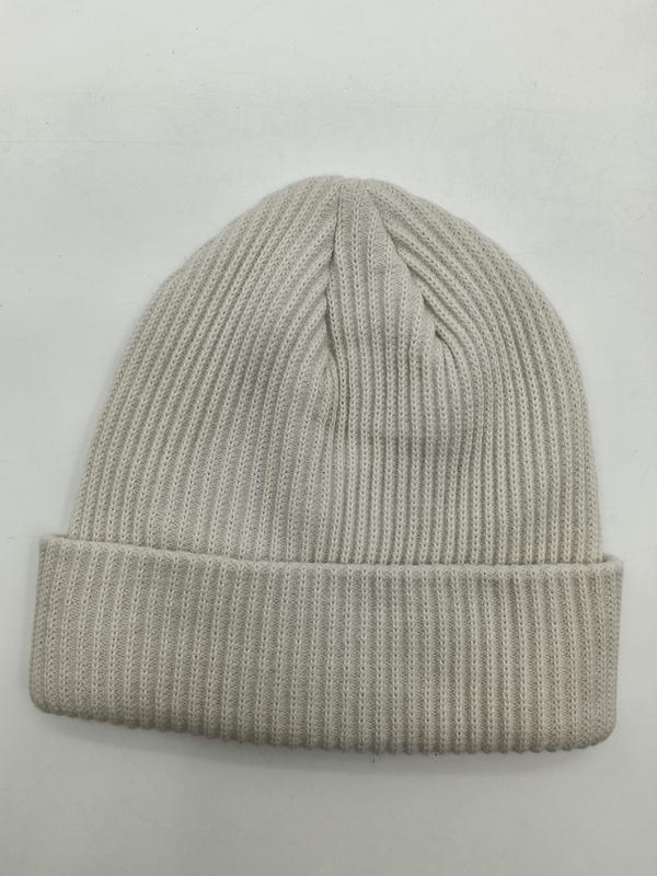 Kremowa czapka beanie z żebrowanej dzianiny z mankietem, widok z góry na białym tle, widoczna tekstura i zagięty brzeg.