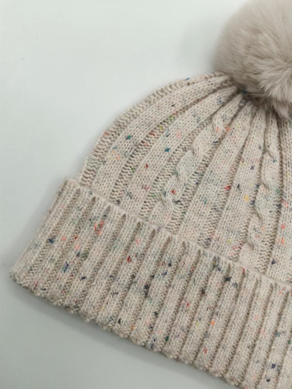 Kremowa czapka beanie o splocie warkoczowym z kolorowymi plamkami, ściągaczem i puszystym pomponem ze sztucznego futra.