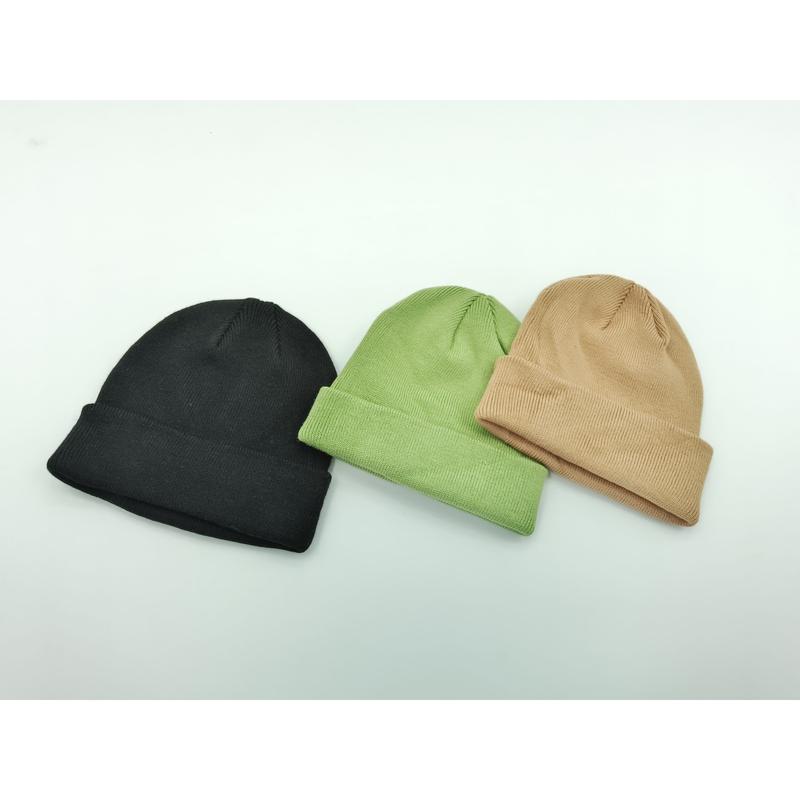 Trzy czapki beanie z mankietem ułożone na białym tle: czarna, szałwiowa zieleń i beżowa.