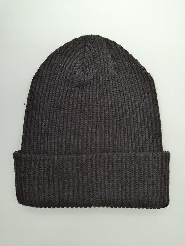 Ciemnoszara prążkowana czapka beanie z podwiniętym rondem, leżąca płasko na białym tle.