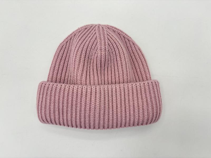 Różowa prążkowana czapka zimowa beanie z podwiniętym mankietem, widok z góry na białym tle.