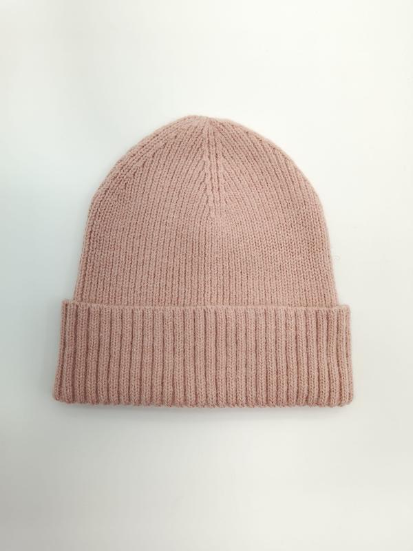 Różowa prążkowana czapka zimowa beanie z szerokim podwiniętym mankietem na białym tle.