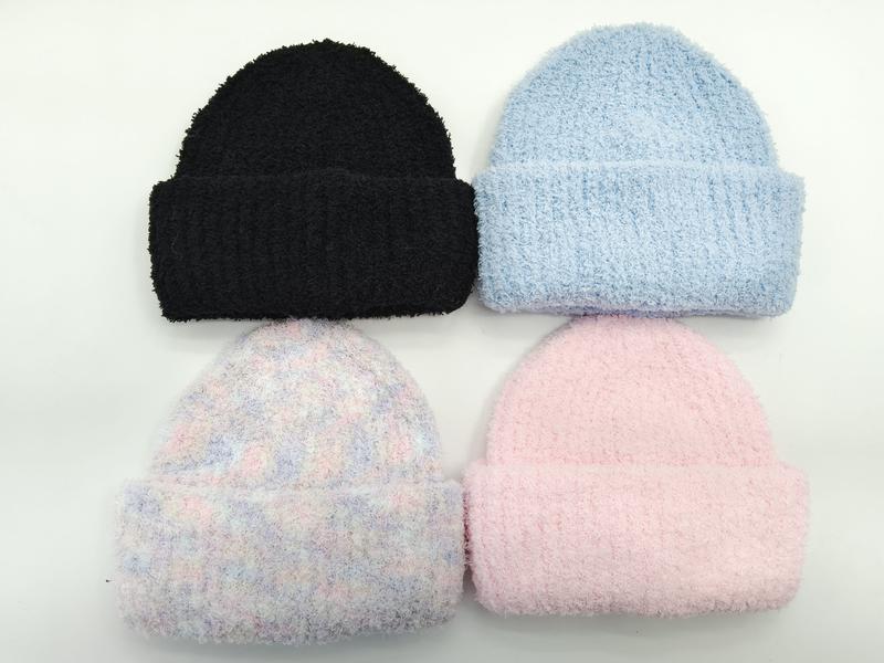 Cztery puszyste czapki beanie: czarna, błękitna, różowa i wielokolorowa w kratę, ułożone płasko na białym tle.