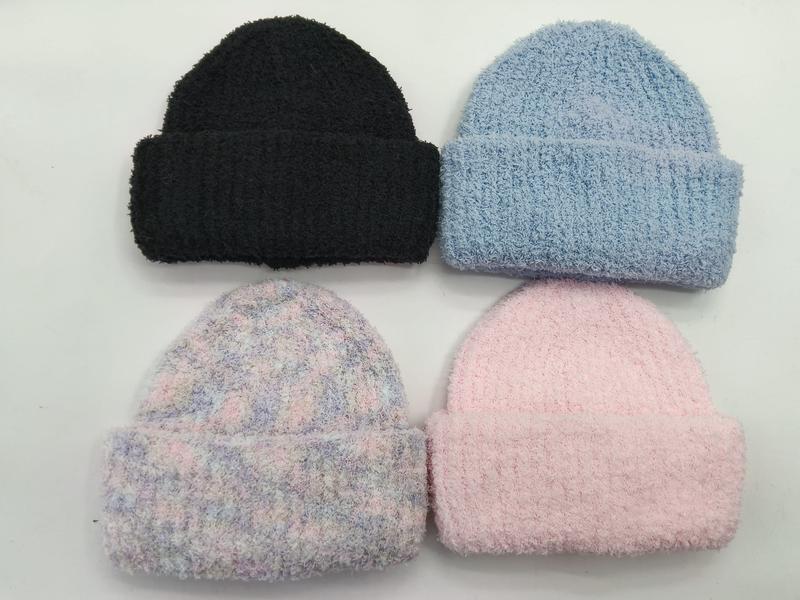 Cztery puszyste czapki beanie z mankietem w kolorach: czarnym, błękitnym, pastelowym tie-dye i różowym na białym tle.