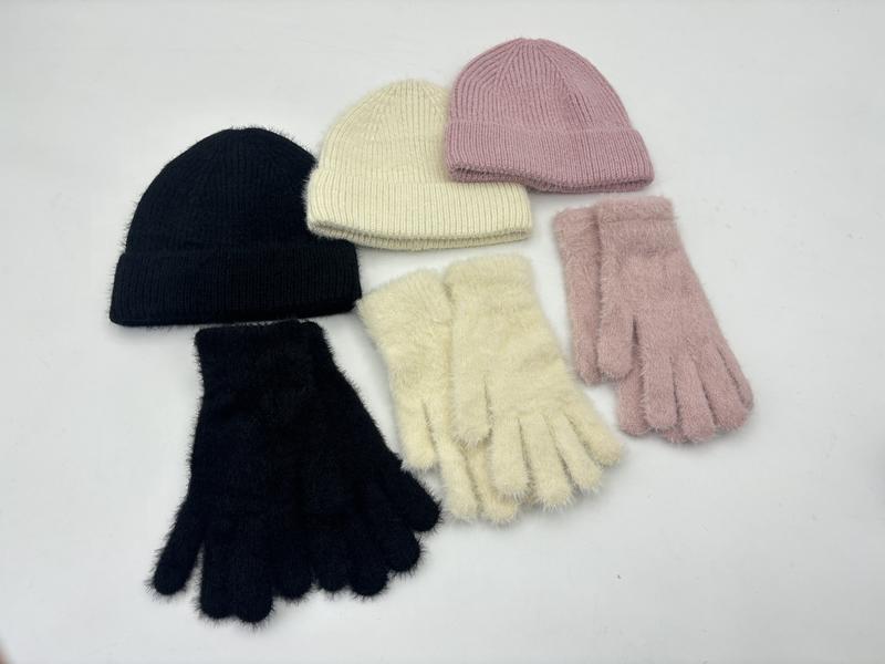 Trzy komplety rękawiczek i czapek beanie z puszystej dzianiny w kolorach czarnym, kremowym i różowym na białym tle.