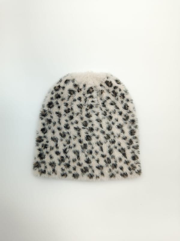 Płaska czapka beanie z miękkiej dzianiny w kolorze ecru z czarno-brązowym wzorem w cętki leoparda.