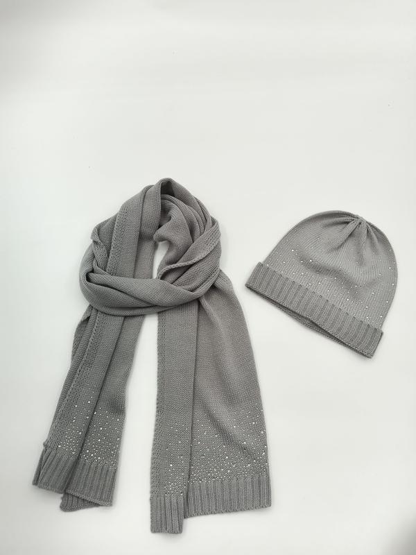 Szary dzianinowy komplet: czapka beanie i długi szalik z kryształkami rhinestone na białym tle.