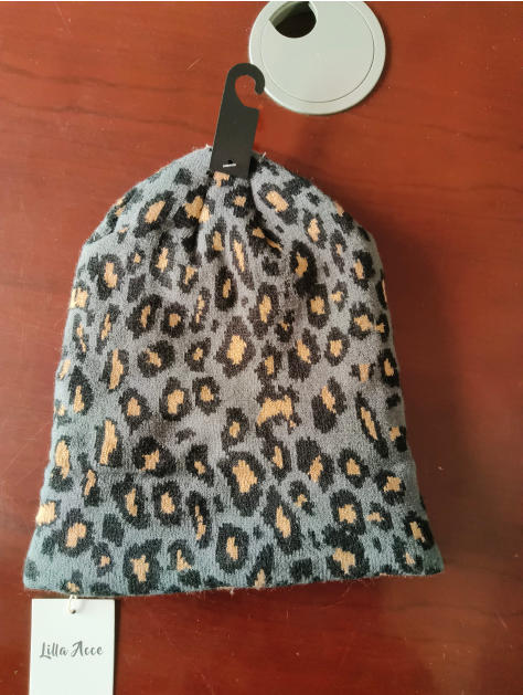 Szara czapka beanie z dzianiny w cętki leoparda w kolorach szarym, czarnym i beżowym.
