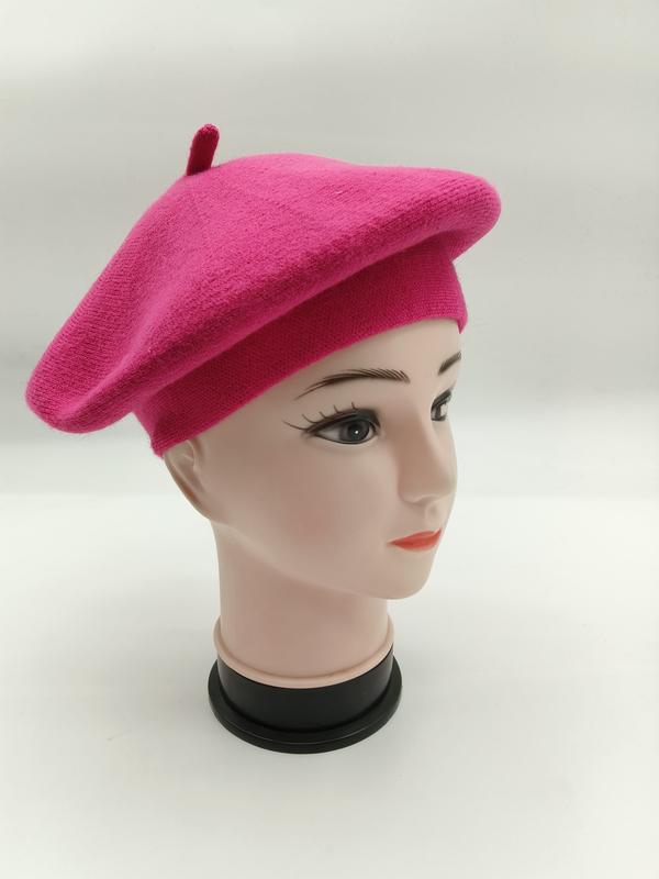 Różowy wełniany beret francuski z guzikiem pośrodku – widok z boku na manekinie.