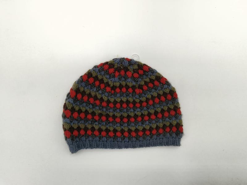 Ręcznie robiona czapka beanie ze wzorem Fair Isle w kolorach niebieskim, czerwonym, oliwkowym i brązowym.
