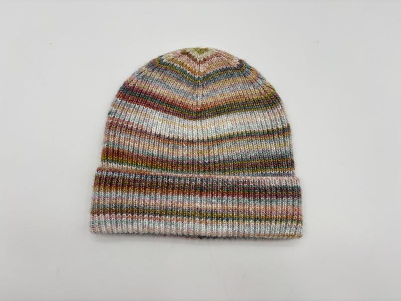 Dzianinowa czapka beanie w wielokolorowe pasy w odcieniach różu, zieleni, błękitu i brązu, z podwiniętym mankietem.