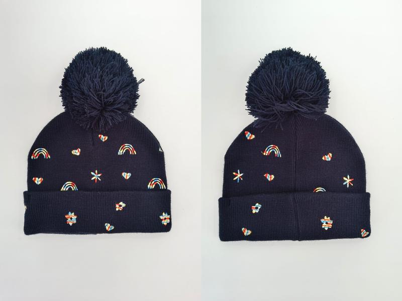 Granatowa czapka beanie z pomponem i kolorowymi haftowanymi motywami tęczy, serc, gwiazdek i kwiatków.