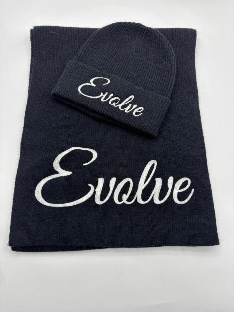 Granatowa czapka beanie i szalik z dzianiny z białym haftowanym napisem kursywą na białym tle.