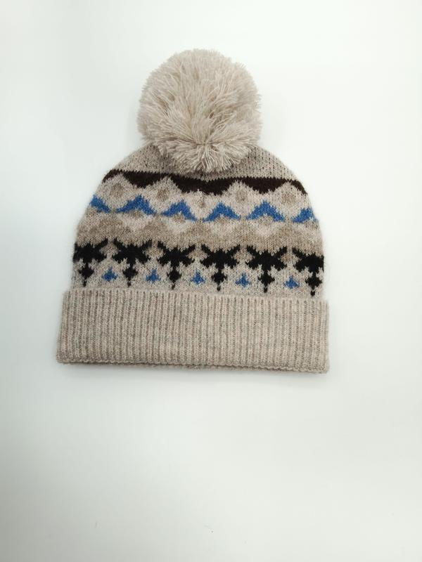 Owsiankowa czapka beanie z wzorem Fair Isle w niebiesko-czarne płatki śniegu i kremowym pomponem.