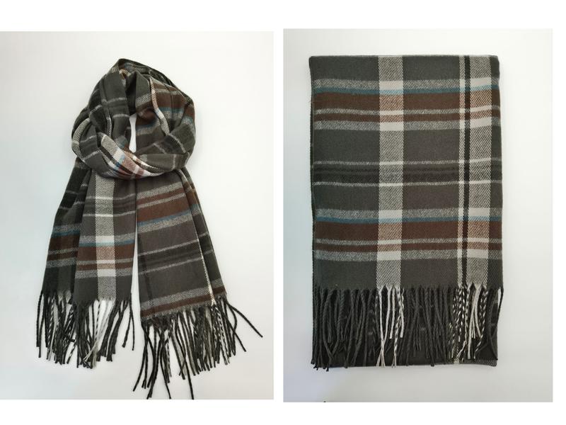 Oliwkowy szalik w kratę tartan z brązowymi, białymi i niebieskimi paskami oraz frędzlami na końcach.