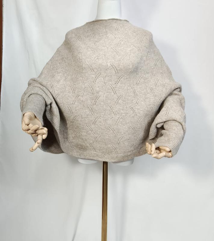 Beżowy sweter oversize z dzianiny pointelle z balonowymi rękawami, prezentowany na manekinie.