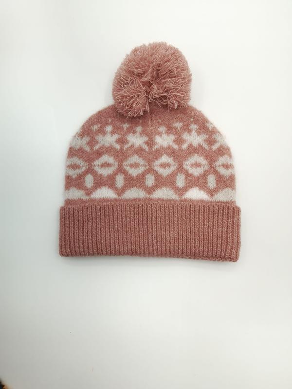 Różowa czapka beanie Fair Isle z pomponem i geometrycznym wzorem śnieżynki, białe tło.