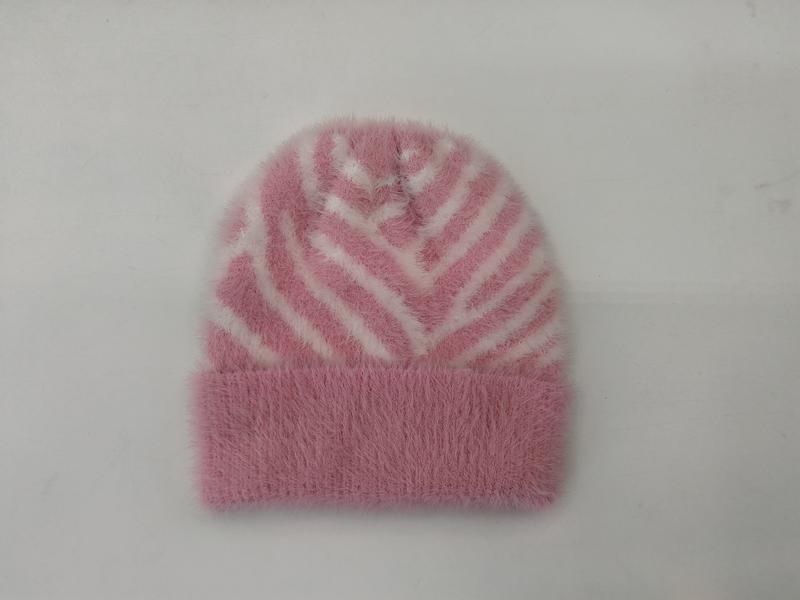 Różowa puszysta czapka beanie w białe paski zebry ze złożonym mankietem, widok z góry na białym tle.