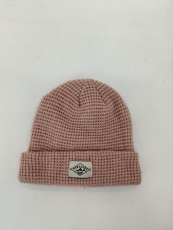 Różowa czapka beanie z dzianiny waflowej z mankietem i naszytą etykietą, na białym tle.
