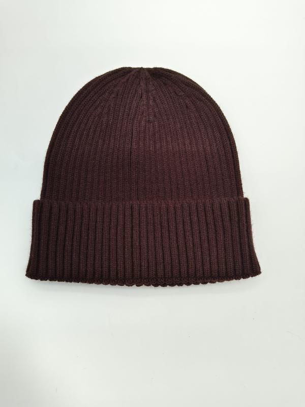 Bordowa czapka beanie z prążkowanej dzianiny ze złożonym mankietem, widok z góry, białe tło.