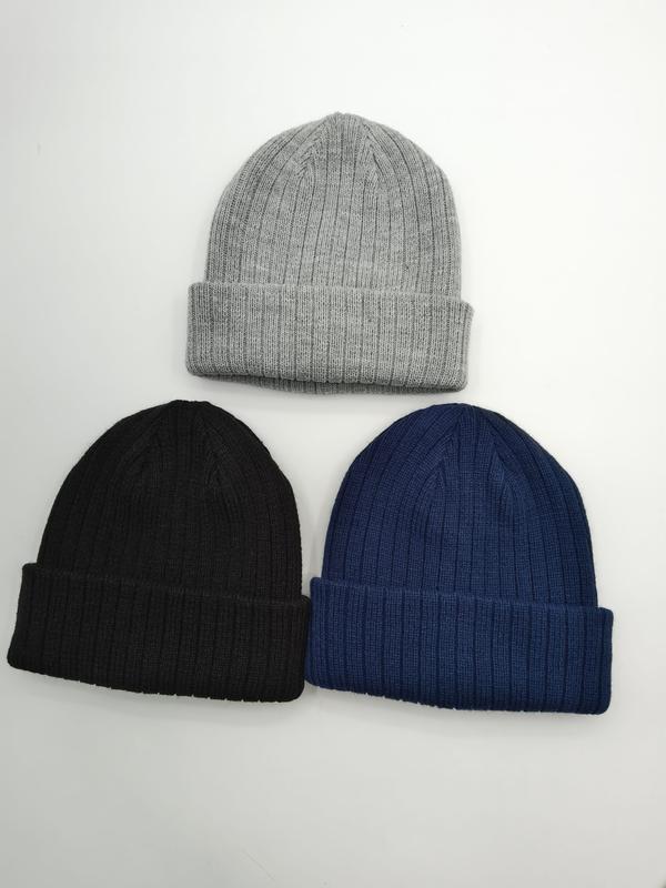 Trzy prążkowane czapki beanie z mankietem w kolorach jasnoszarym, czarnym i granatowym na białym tle.