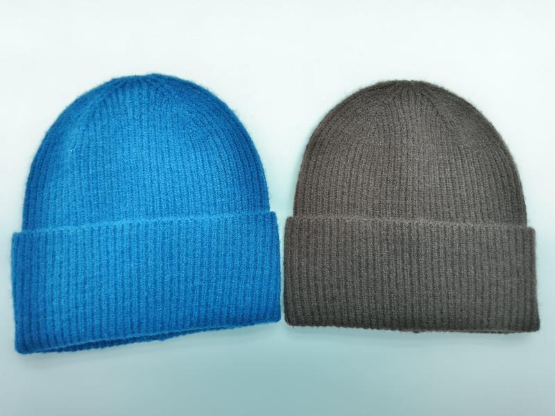 Dwa prążkowane czapki beanie z mankietem – niebieska i brązowo-taupe – na białym tle.