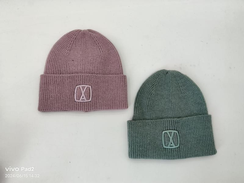 Dwie prążkowane czapki beanie z mankietem w kolorze różowego mauve i szałwiowej zieleni z wytłaczanym logo.