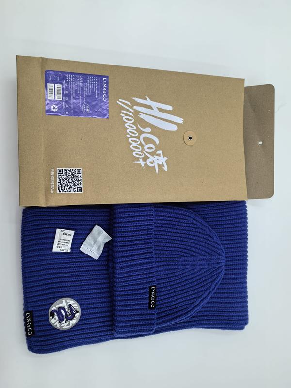 Granatowy prążkowany komplet zimowy: czapka beanie i szalik z naszywką logo, zapakowane w pudełko kraft.