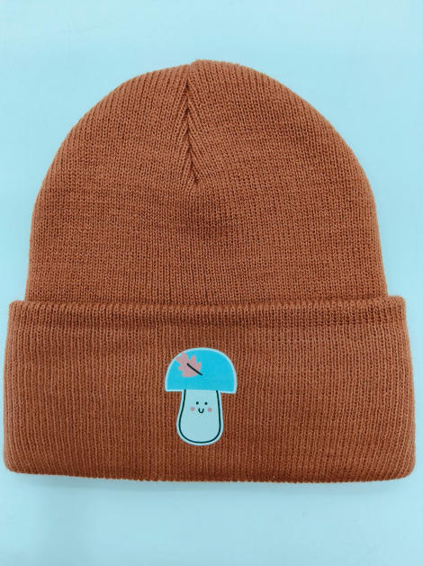 Rdzawobrązowa prążkowana czapka beanie z podwiniętym mankietem i uroczą naszywką z niebieskim grzybkiem kawaii.