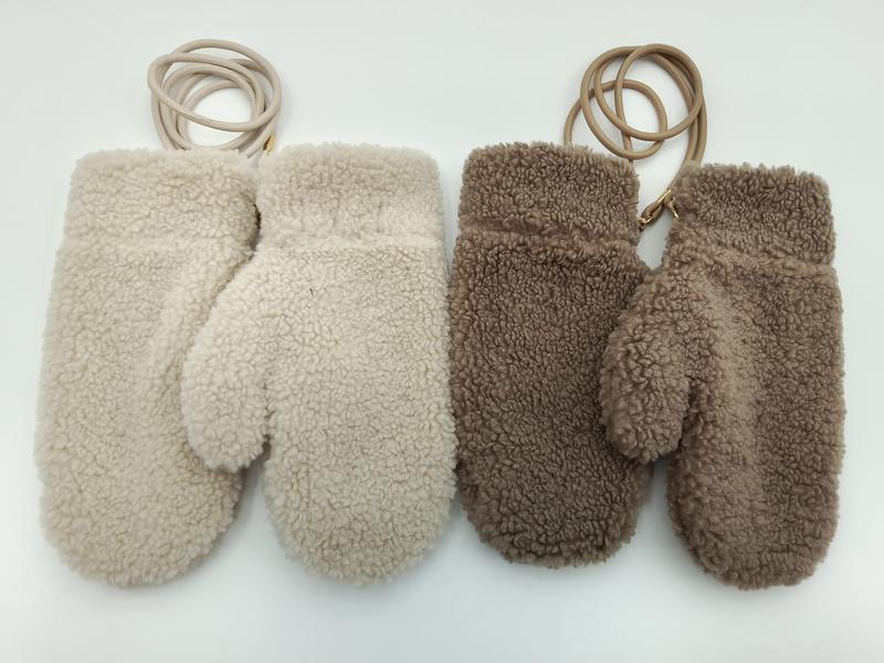 Kremowe i taupe rękawiczki sherpa fleece z skórzanym sznurkiem przy nadgarstku, ułożone na białym tle.