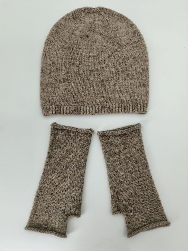 Szarobeżowa melanżowa czapka beanie i rękawiczki bez palców ułożone na białym tle.