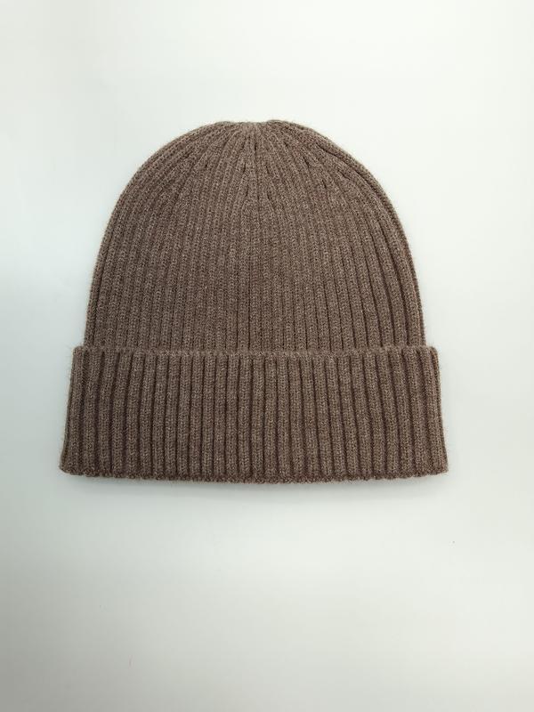 Szara czapka beanie z prążkowanej dzianiny z podwiniętym mankietem, ułożona płasko na białym tle.
