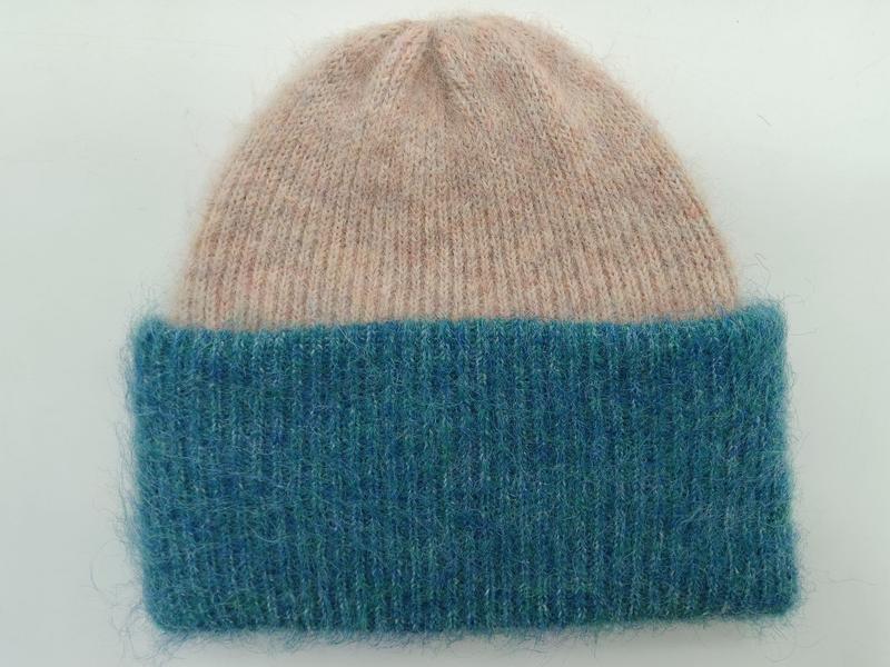 Dwukolorowa czapka beanie z różową koroną i turkusowym ściągaczem, miękki puszysty splot, zdjęcie na białym tle.