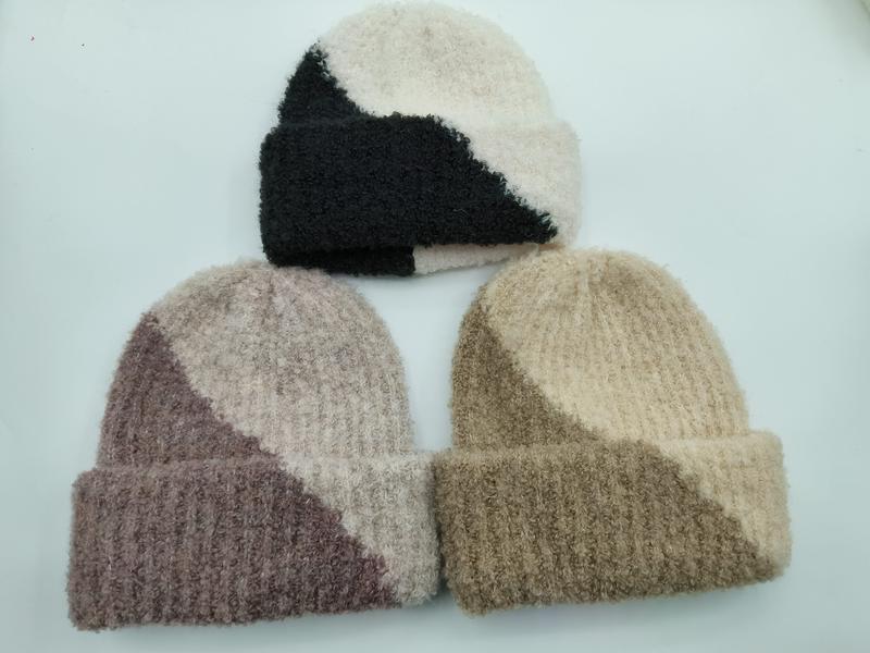 Trzy dwukolorowe czapki beanie: czarno-kremowa, różowo-pudrowa i beżowo-khaki, z prążkowanym mankietem, na białym tle.